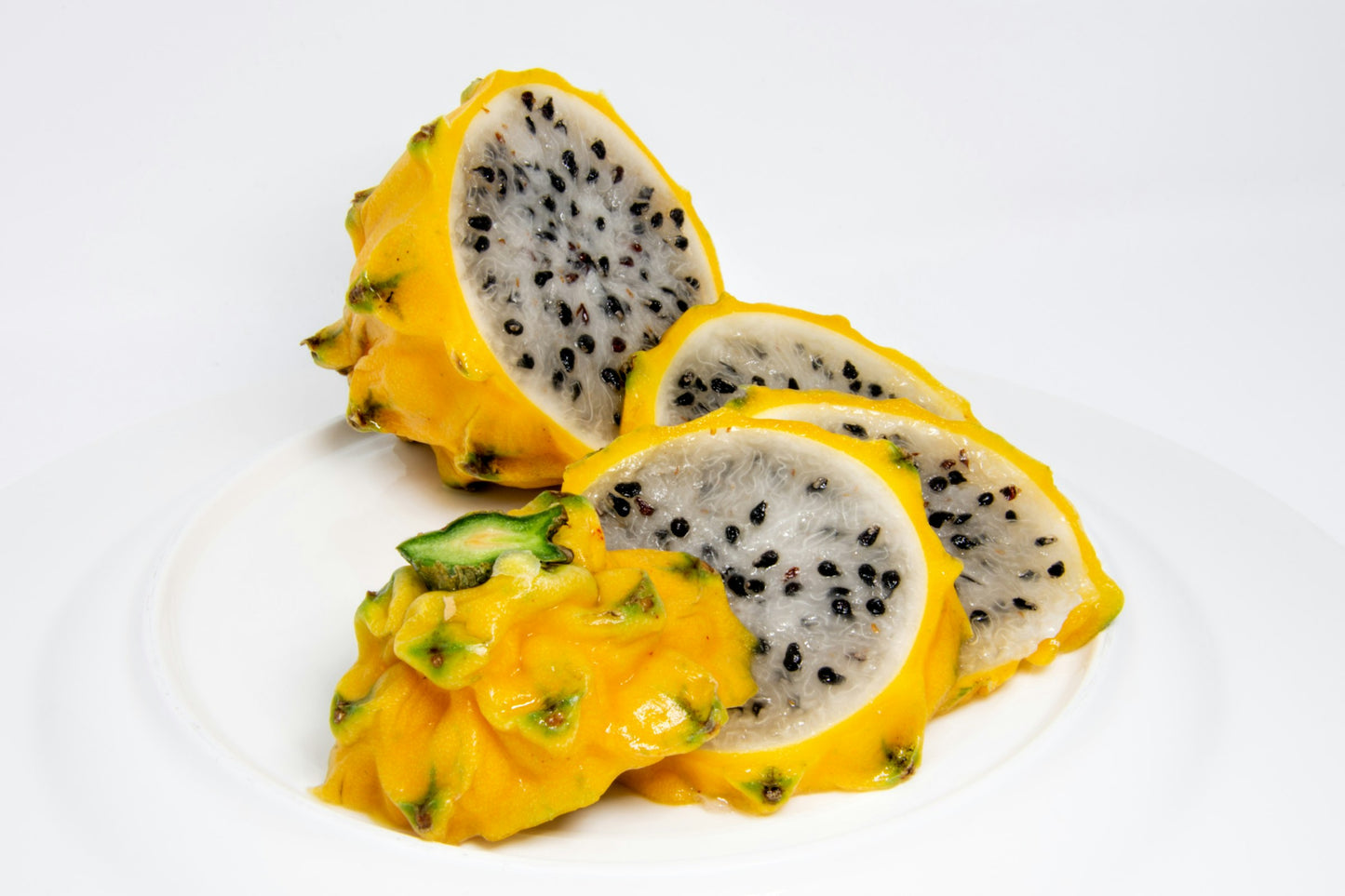 Fresh yellow pitaya dragon fruit halved showing white flesh